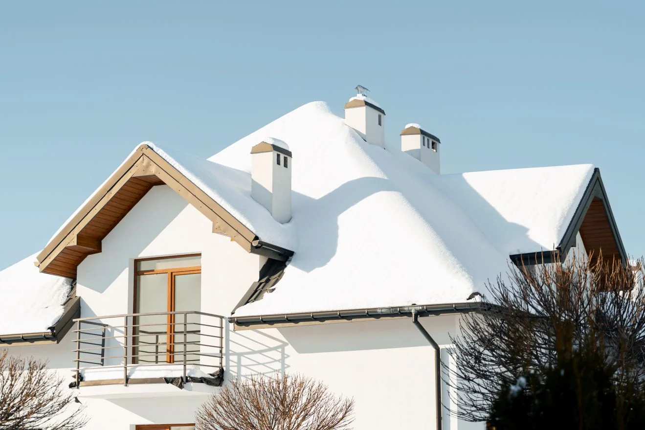 House with a snow covered roof on a clear winter day