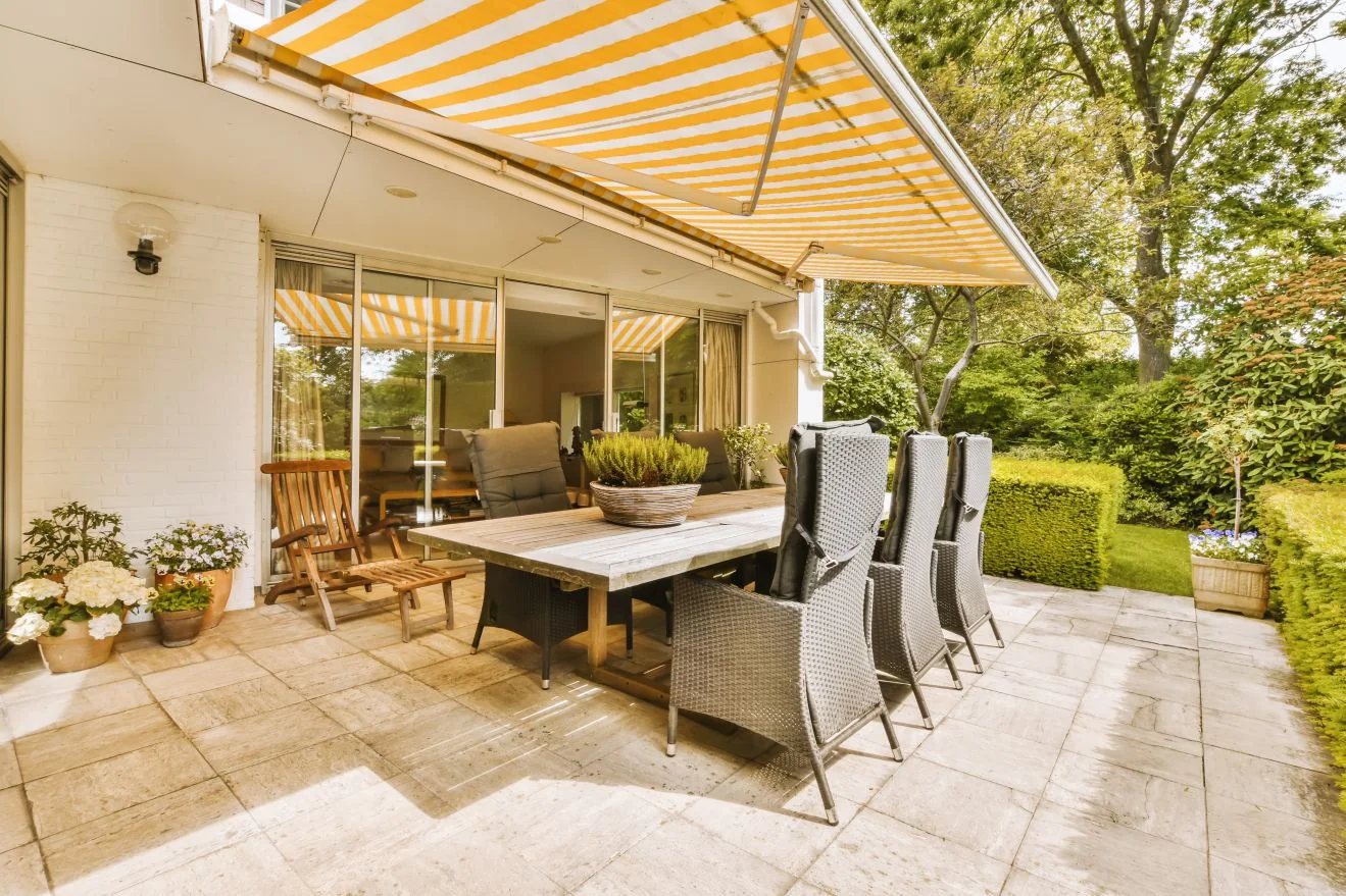 Yellow striped awning over a patio dining table