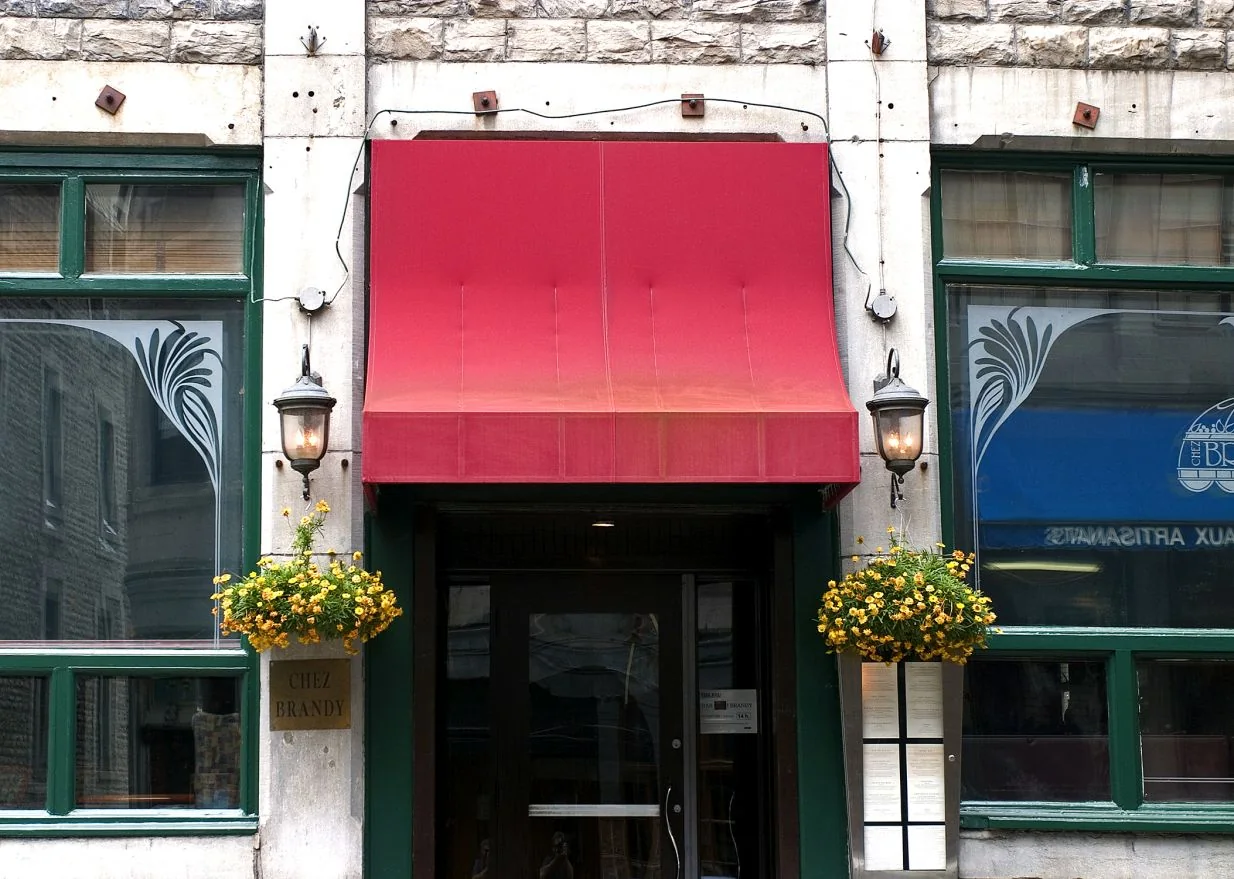 Red fabric canopy over a business entrance