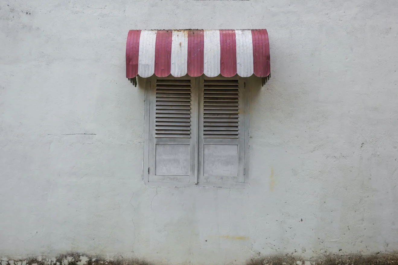 Striped fabric awning over a window