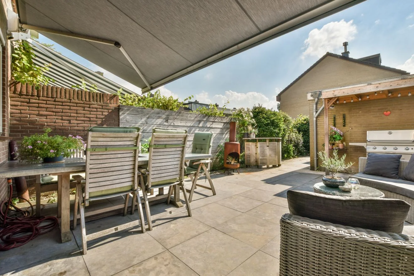 Patio table and chairs in the shade of a retractable awning