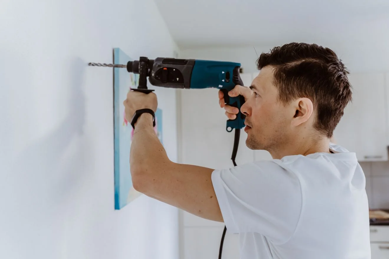 Handyman using a drill on an interior wall